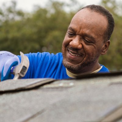 Colleague on roof with hammer