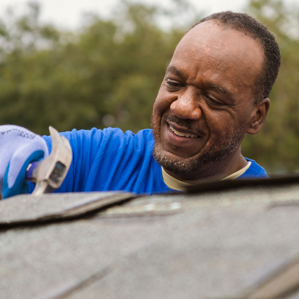 Colleague on roof with hammer