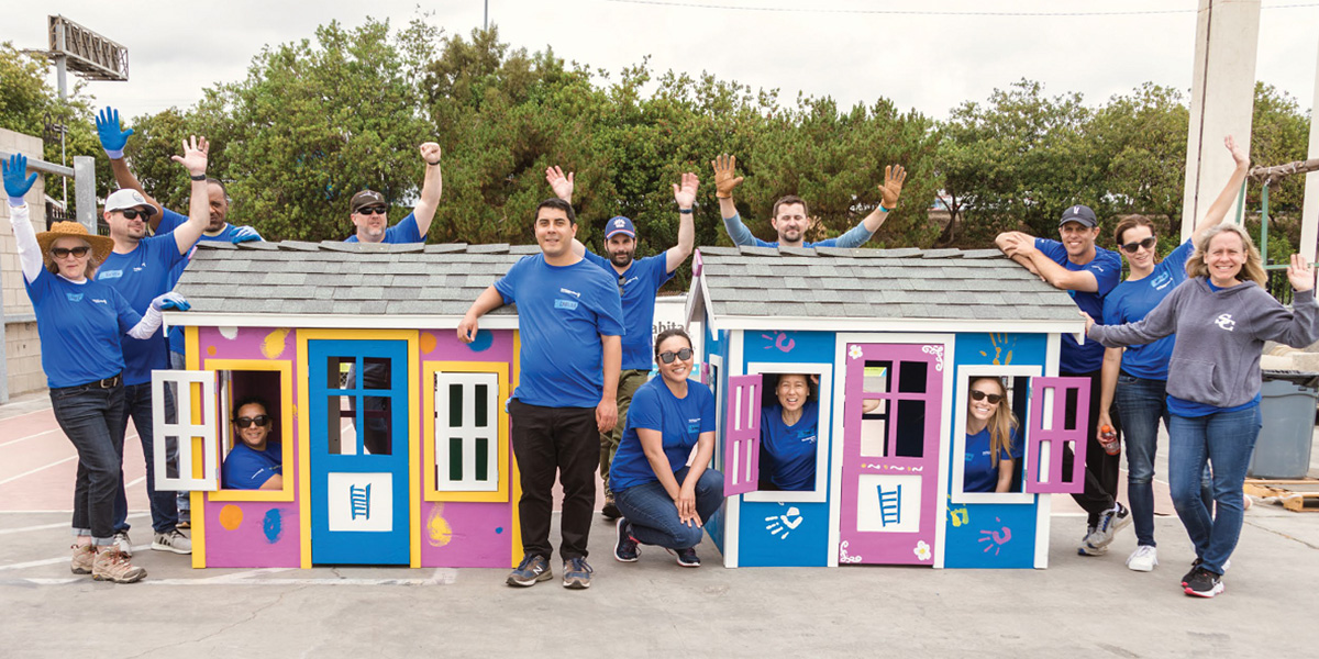 Volunteers painting toy houses