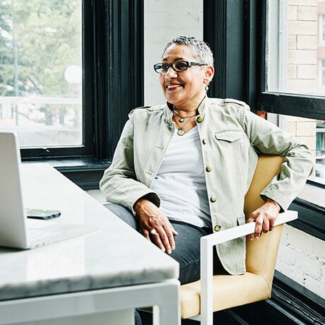 Preferred Banking client reviews financial picture on laptop at desk.