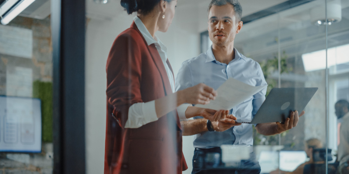 Two professionals discuss in office