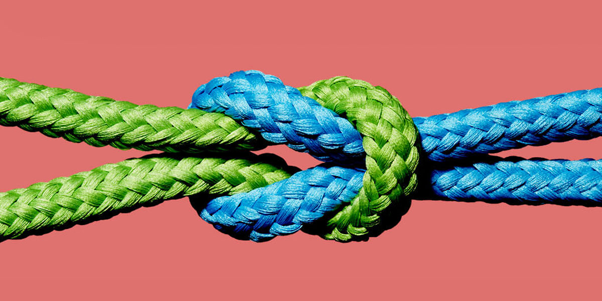 Different colored ropes tied in knot.