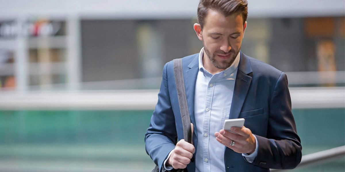 A man looks down at his mobile phone