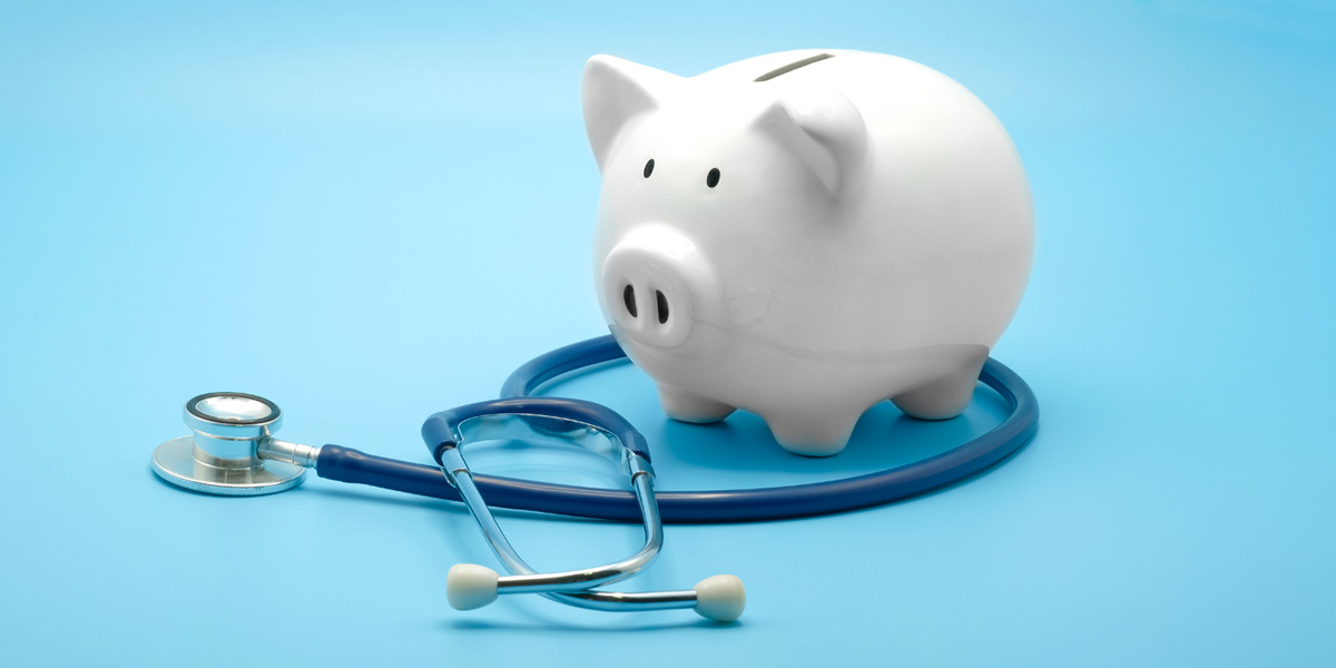 Stethoscope wrapped around a piggy bank