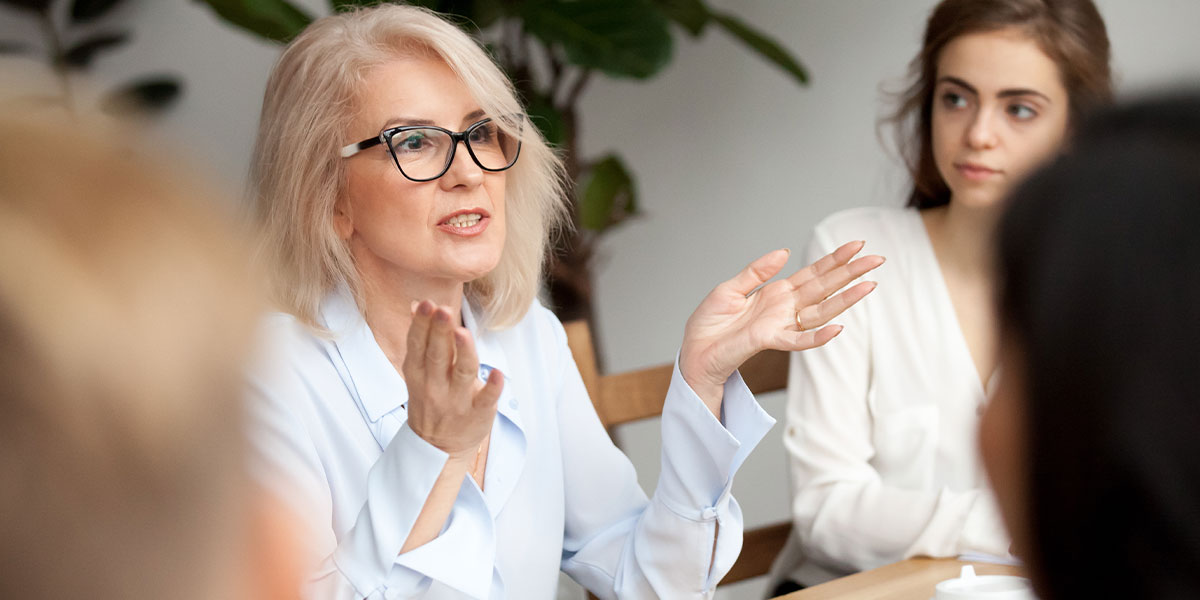 Female entrepreneur demonstrating her leadership skills when addressing her staff.