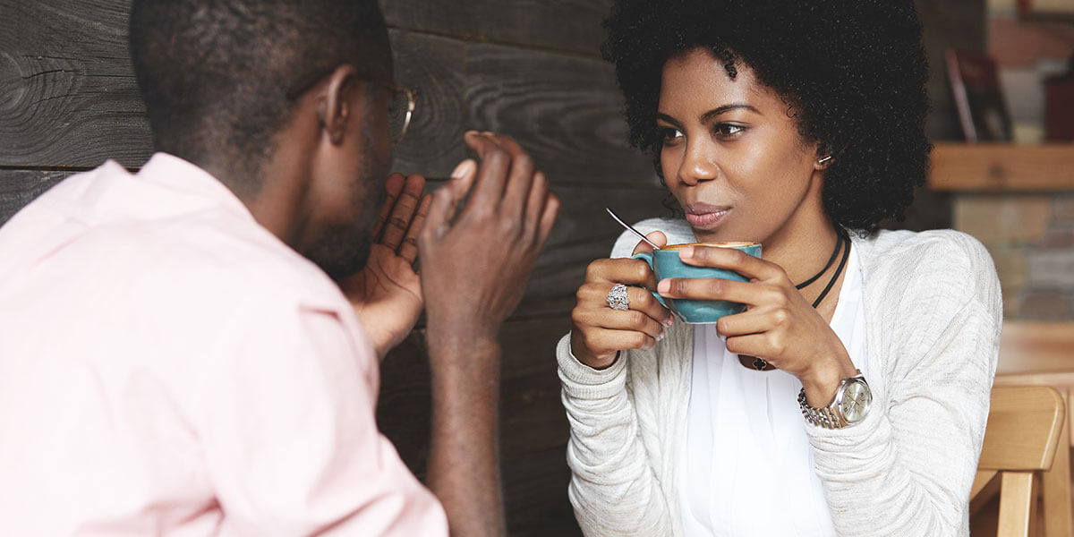 Couple discusses how to manage and merge their finances over a cup of coffee.