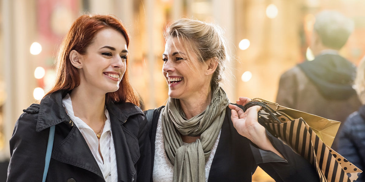 Mother teaches her daughter about using credit cards responsibly while shopping together. 