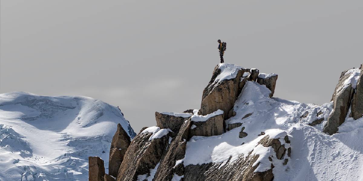 Hiker standing on top of snowy peak