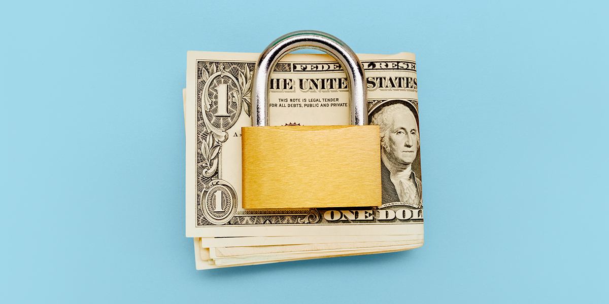 Closed padlock atop folded money