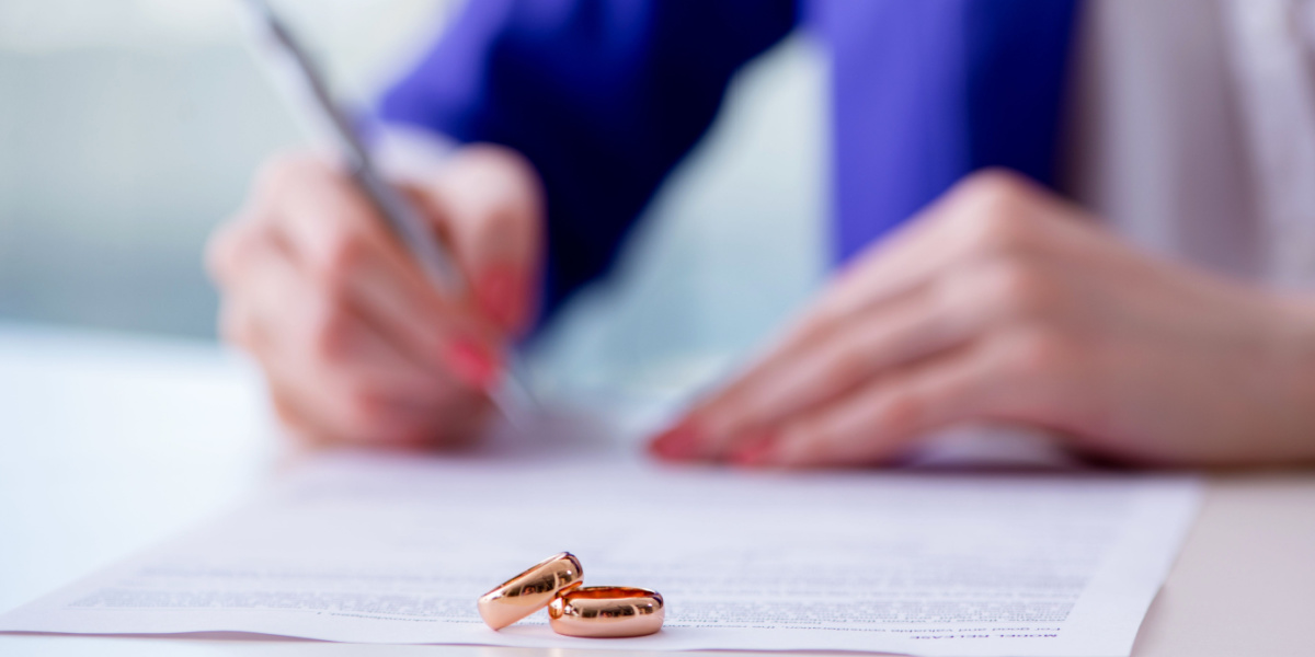 Pair of wedding rings on contract being signed