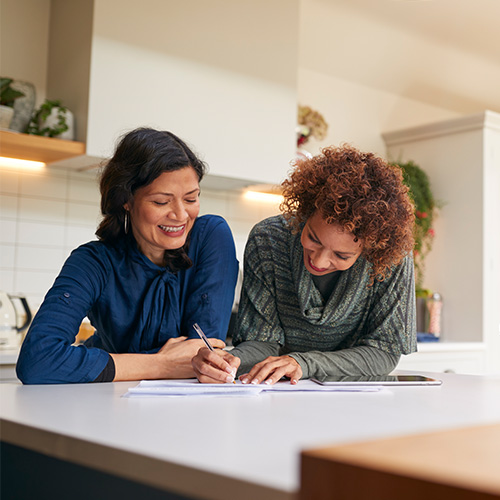 Two people signing mortgage loans in a home