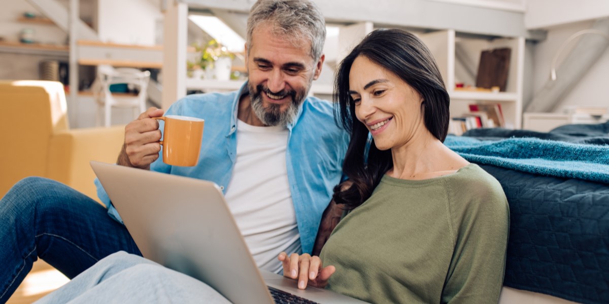 A couple using a laptop to online bank at home