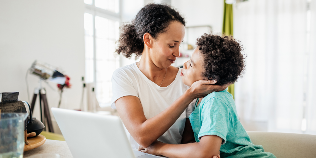 A mother and son hug in the living room