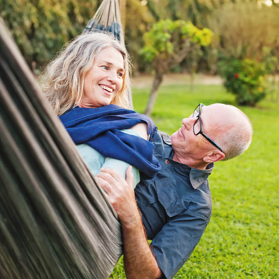 Senior couple hangs on a hammock thinking about City National Bank's retirement planning