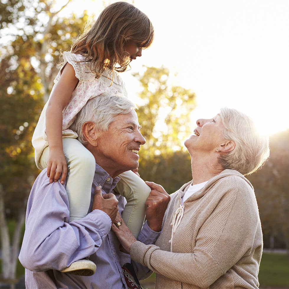 Grandparents enjoying sunset with their granddaughter.