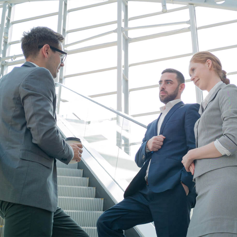 Colleagues discuss work with a staircase in the background creating a platform for City National Bank's trust estate services